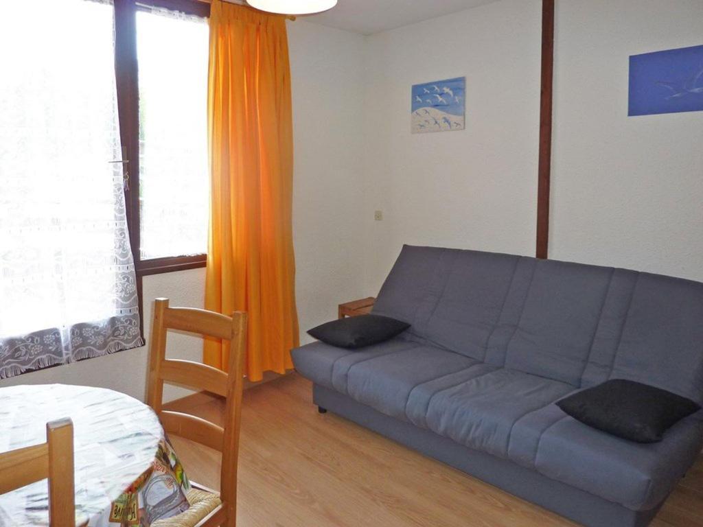 a living room with a couch and an orange curtain at Appartement Les Orres, 1 pièce, 4 personnes - FR-1-322-177 in Les Orres