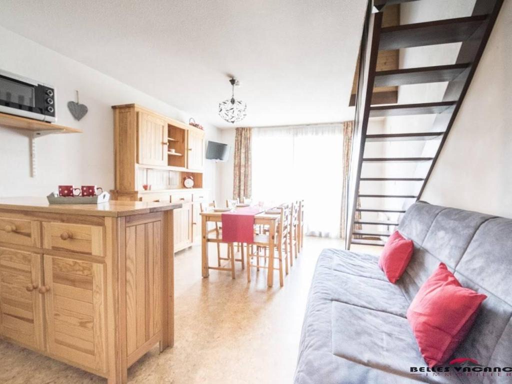 une cuisine et un salon avec un canapé et une table dans l'établissement Appartement pour 6 pers. avec balcon près de Saint-Lary, Wi-Fi et parking gratuits - FR-1-296-215, à Saint-Lary-Soulan