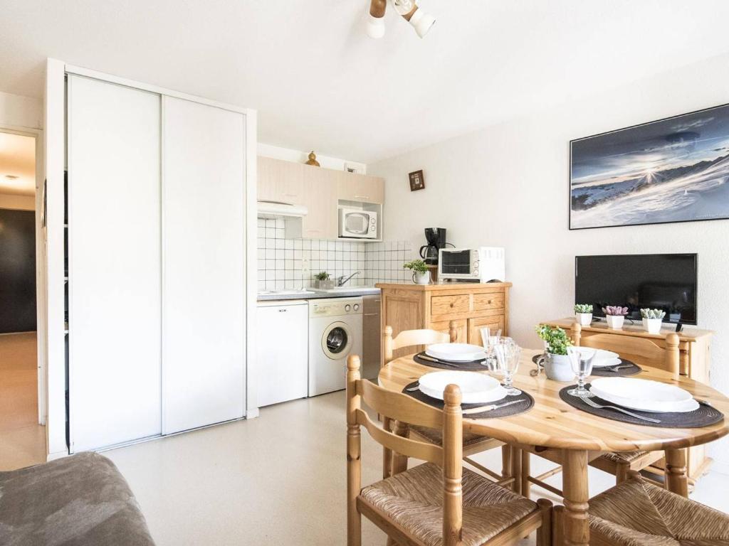 une cuisine et une salle à manger avec une table et des chaises en bois dans l'établissement Appartement Cosy 6 Pers à Saint Lary - Quartier Thermal - Proche Télécabine, Parking Privé - FR-1-296-216, à Saint-Lary-Soulan