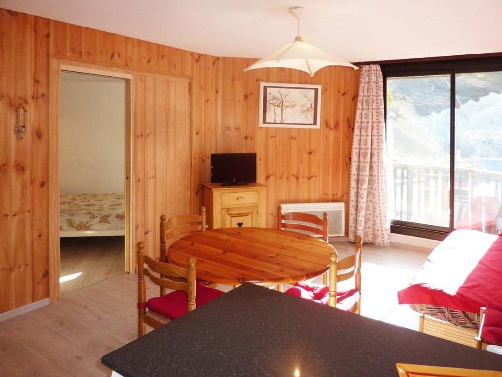 a living room with a dining room table and a television at Appartement Les Orres, 2 pièces, 5 personnes - FR-1-322-280 in Les Orres