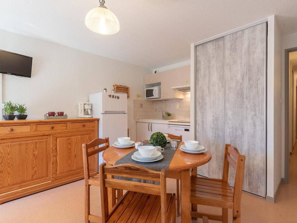 a dining room with a table and chairs and a kitchen at Appartement Saint-Lary-Soulan, 2 pièces, 6 personnes - FR-1-296-154 in Saint-Lary-Soulan