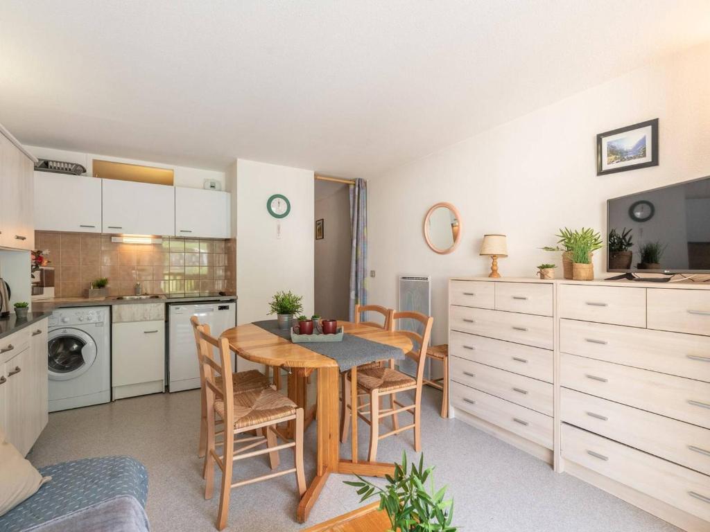 une cuisine avec une table et des chaises dans une pièce dans l'établissement Charmant appartement 4 pers. avec balcon, parking privé et casier à skis, proche centre Saint-Lary - FR-1-296-220, à Saint-Lary-Soulan