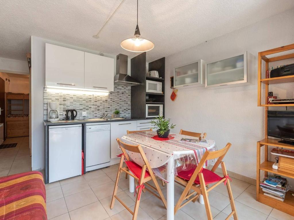 a kitchen with a table and chairs in a room at Appartement Saint-Lary-Soulan, 1 pièce, 4 personnes - FR-1-296-218 in Saint-Lary-Soulan