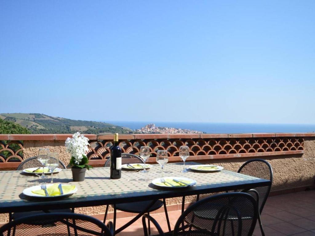 einen blauen Tisch mit Weingläsern auf dem Balkon in der Unterkunft Maison Banyuls-sur-Mer, 5 pièces, 8 personnes - FR-1-225C-470 in Banyuls-sur-Mer