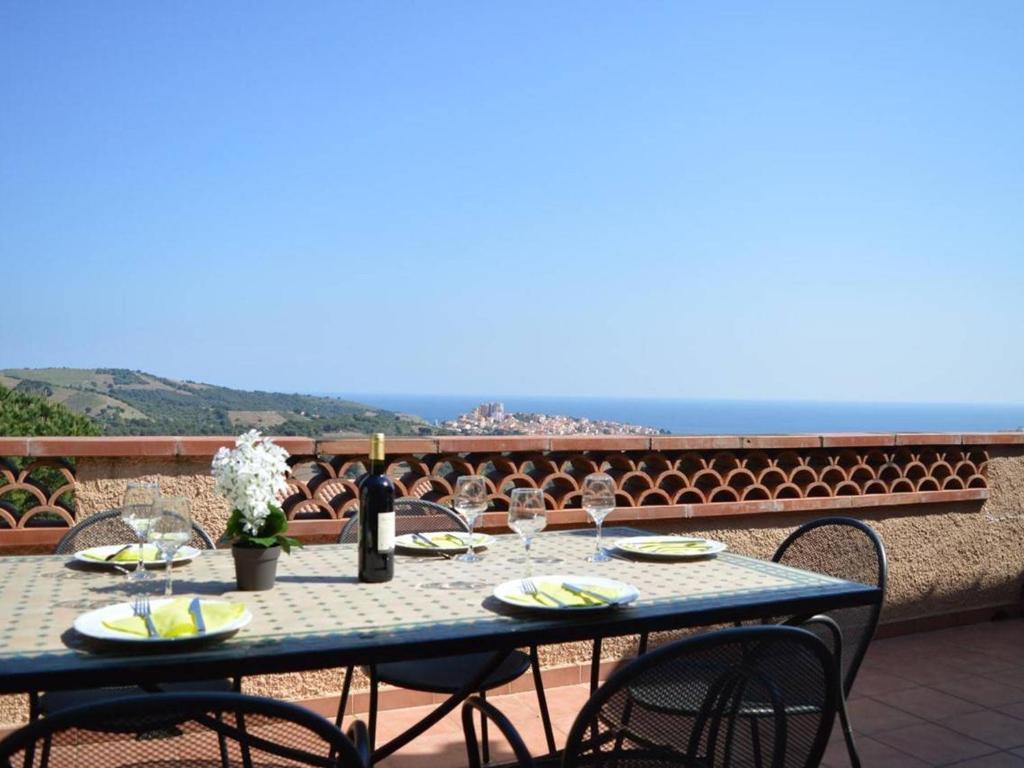 a blue table with wine glasses on a balcony at Villa 5 pièces 3 chambres avec jardin, clim, wifi, animaux admis - FR-1-225C-470 in Banyuls-sur-Mer