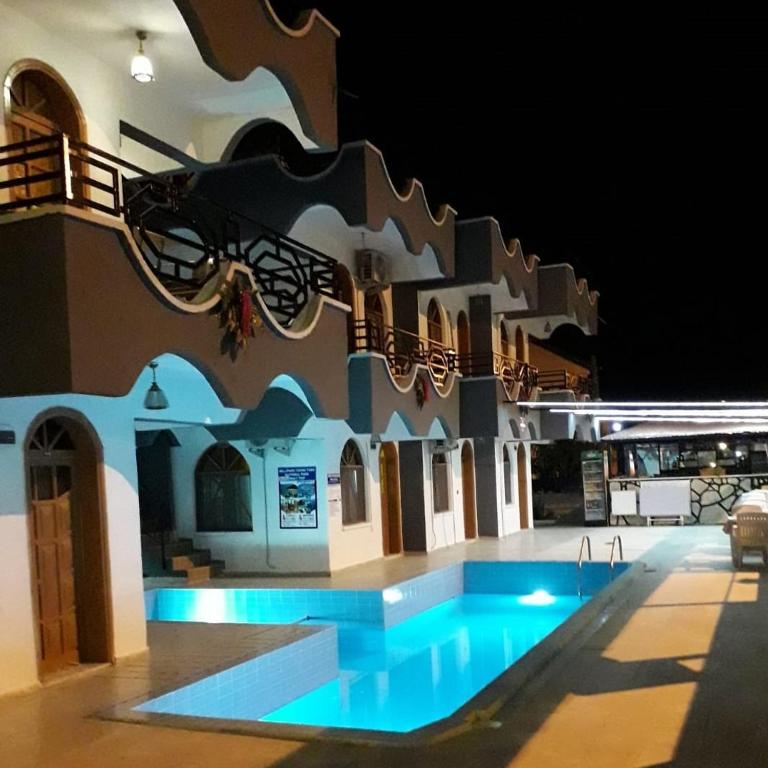 a building with a swimming pool at night at Sincer Otel in Kuşadası