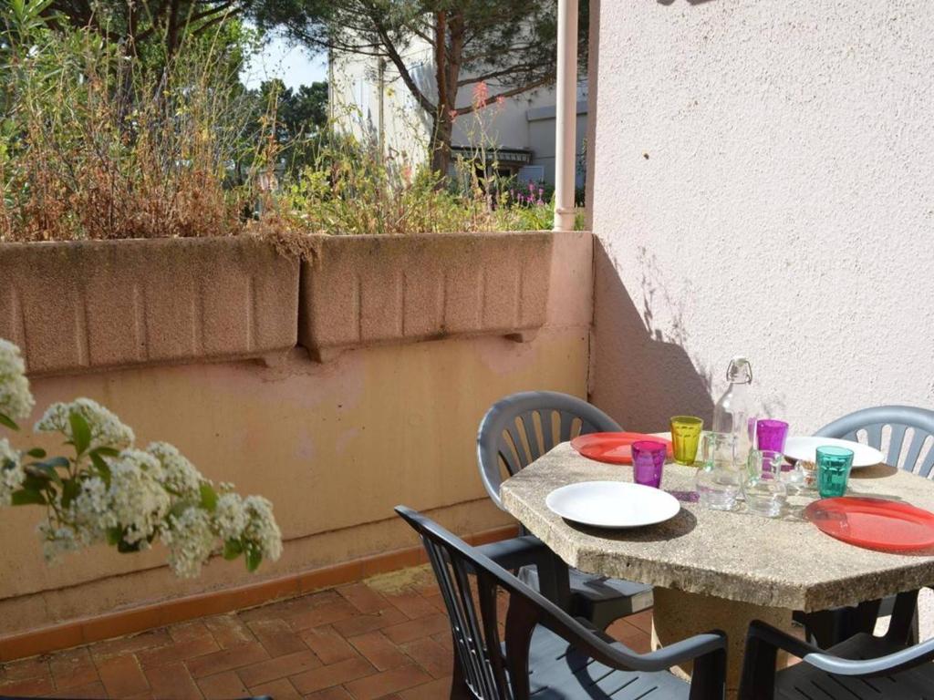 une table et des chaises assises sur une terrasse dans l'établissement Studio avec Terrasse, Proche Plage et Commerces à Argelès-sur-Mer - FR-1-225-449, à Argelès-sur-Mer