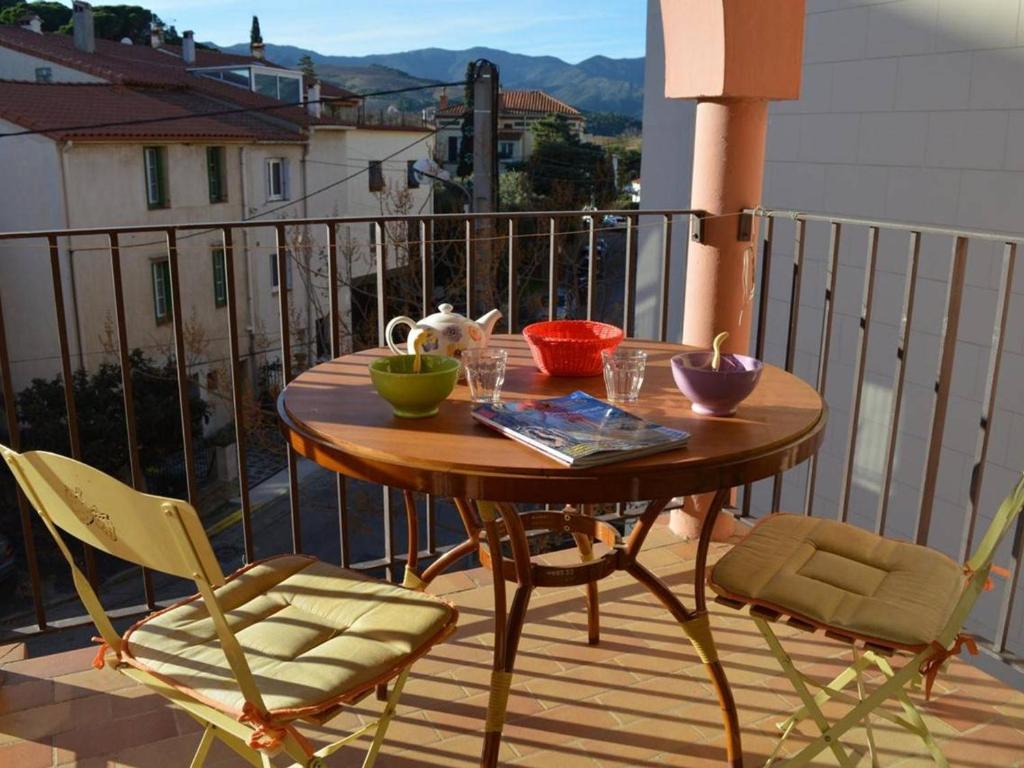 une table et des chaises en bois sur un balcon dans l'établissement Studio cabine à 50m de la plage avec terrasse et lave-linge - FR-1-225C-461, à Banyuls-sur-Mer