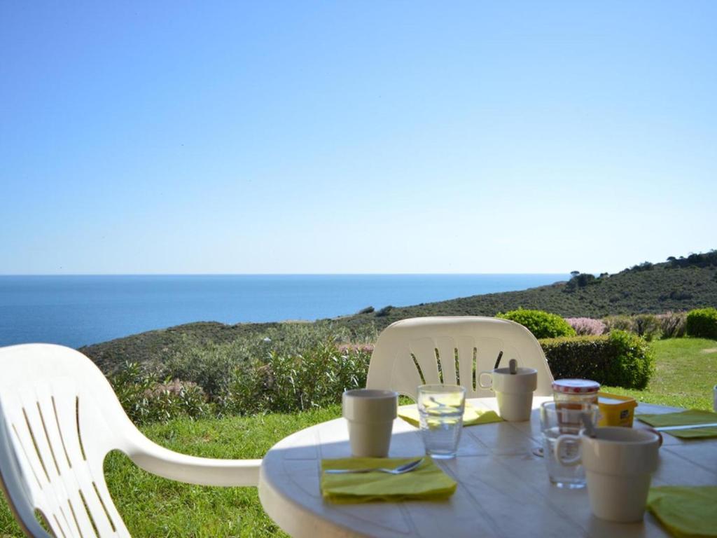 - une table et deux chaises avec vue sur l'océan dans l'établissement Appartement 2 pièces avec terrasse, WIFI et parking à Banyuls-sur-Mer - FR-1-225C-488, à Banyuls-sur-Mer