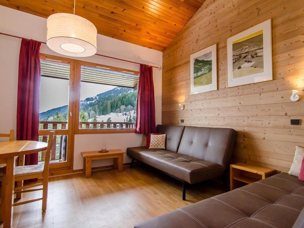 un salon avec un canapé et une grande fenêtre dans l'établissement Appartement 2 pièces à Valmorel avec balcon et casier à skis - FR-1-291-799, à Valmorel