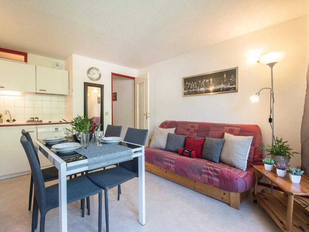 un salon avec un canapé rouge et une table dans l'établissement Appartement pour 4 à Saint-Lary, proche centre, balcon, casier à skis, parking municipal - FR-1-296-236, à Saint-Lary-Soulan