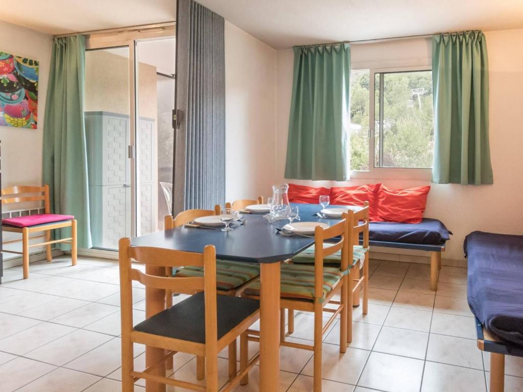 une salle à manger avec une table, des chaises et un canapé dans l'établissement Charmant 2 pièces cabine avec balcon, proche télécabine et centre de Briançon - 4 pers. - FR-1-330C-24, à Briançon