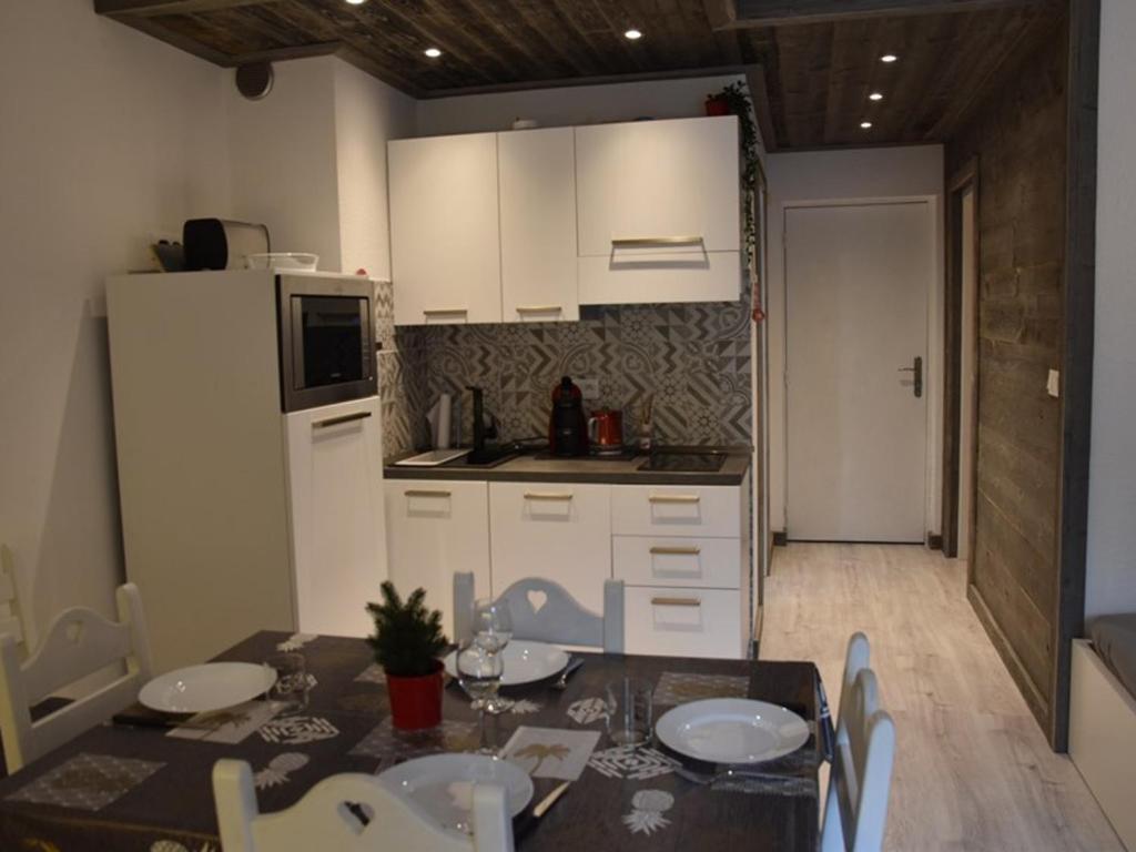 a kitchen with a dining table and a white refrigerator at Appartement Montgenèvre, 2 pièces, 6 personnes - FR-1-266-90 in Montgenèvre