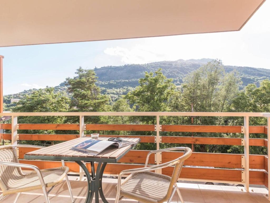 une table et des chaises sur un balcon avec vue dans l'établissement Joli 2 pièces proche commerces, télécabine, balcon, casier à skis - FR-1-330C-32, à Briançon