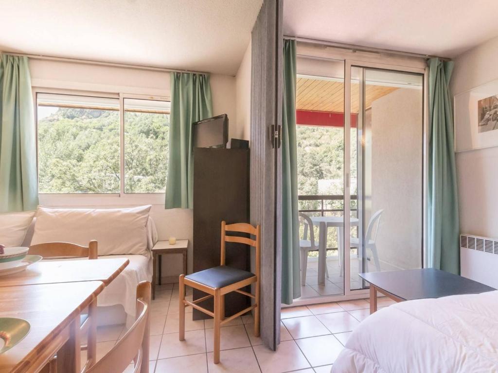 a hotel room with a bed and a table and a balcony at Appartement Briançon, 2 pièces, 6 personnes - FR-1-330C-16 in Briançon