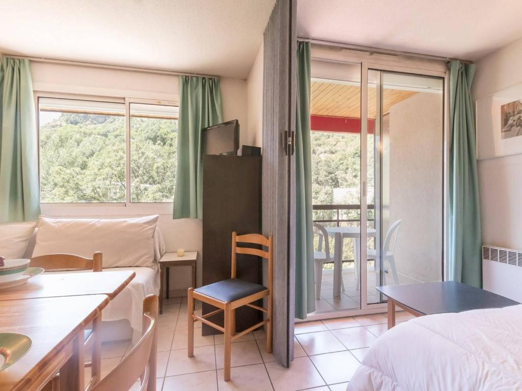 une chambre d'hôtel avec un lit, une table et un balcon dans l'établissement Appartement 2 pièces avec coin nuit, balcon, parking et casier à ski - Proche télécabine et centre - FR-1-330C-16, à Briançon