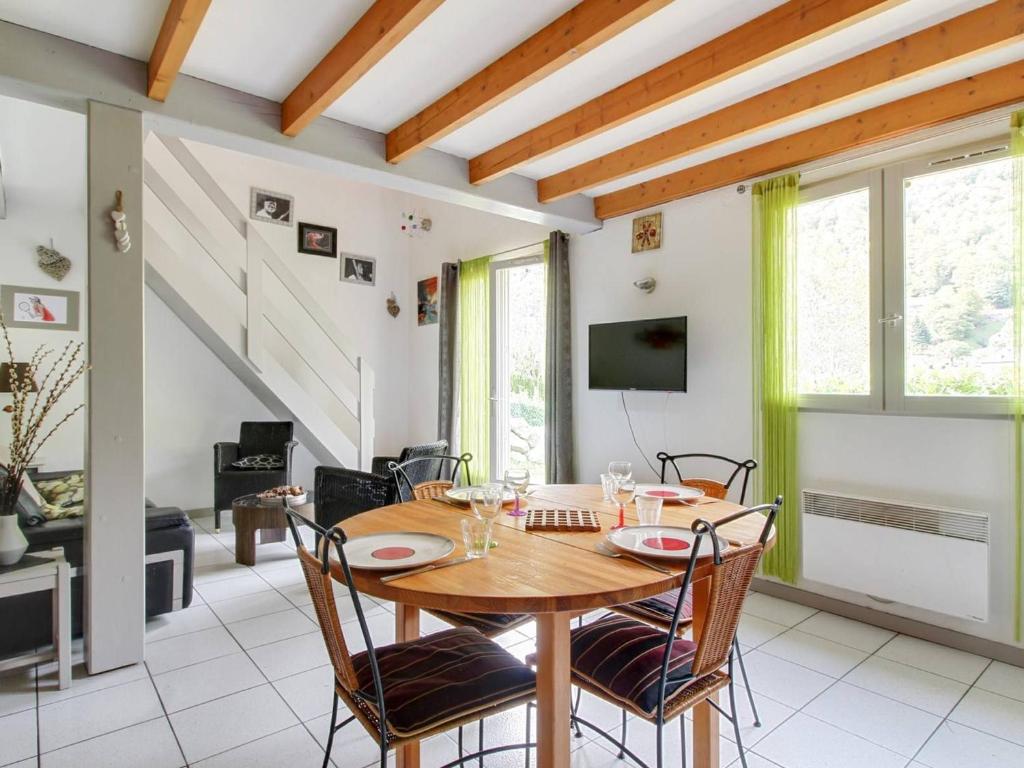 una sala da pranzo con tavolo e sedie in legno di Chalet mitoyen 3 chambres, 60m², belle vue, 1km centre-ville, navette ski, parking, terrasse - FR-1-401-3 a Cauterets