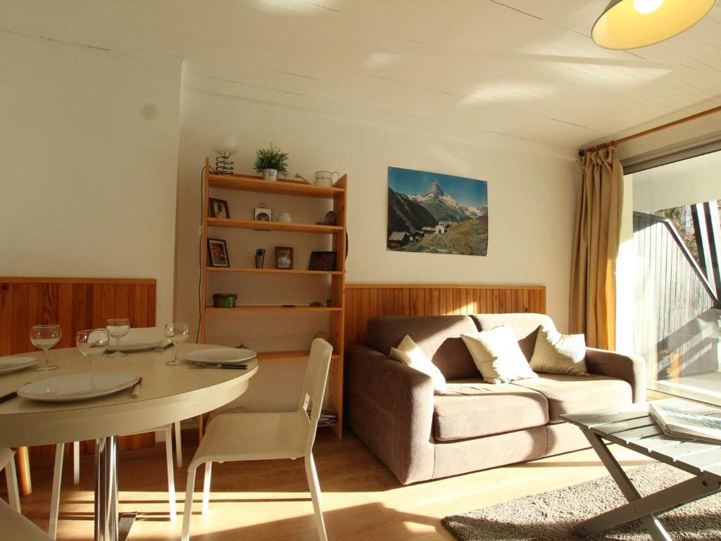 un salon avec une table et un canapé dans l'établissement Appartement cosy pour 6 à Chantemerle, Serre-Chevalier. Balcon, parking, casier à ski, 2 étoiles. - FR-1-330E-33, à Saint-Chaffrey