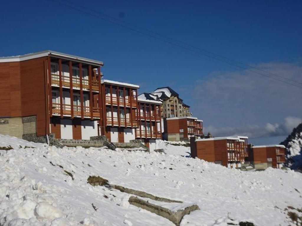 拉姆吉的住宿－Appartement La Mongie, 2 pièces, 6 personnes - FR-1-404-89，积雪覆盖的山顶上的一群建筑