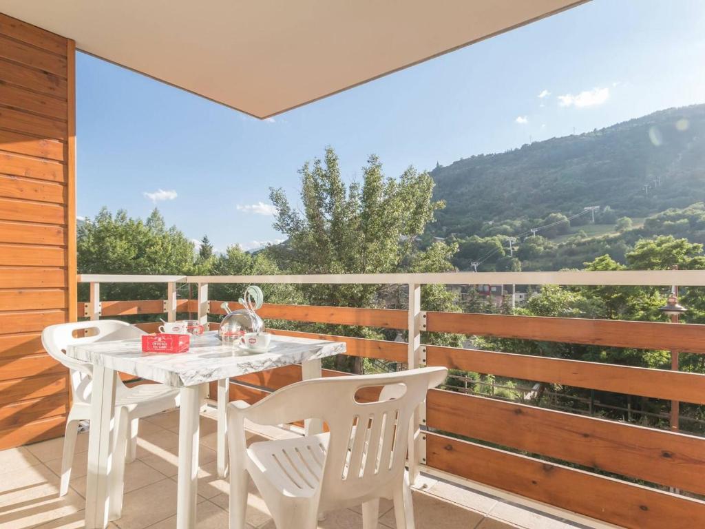 une table blanche et des chaises sur un balcon avec vue dans l'établissement Charmant 2 pièces avec balcon proche télécabine à Briançon - FR-1-330C-35, à Briançon