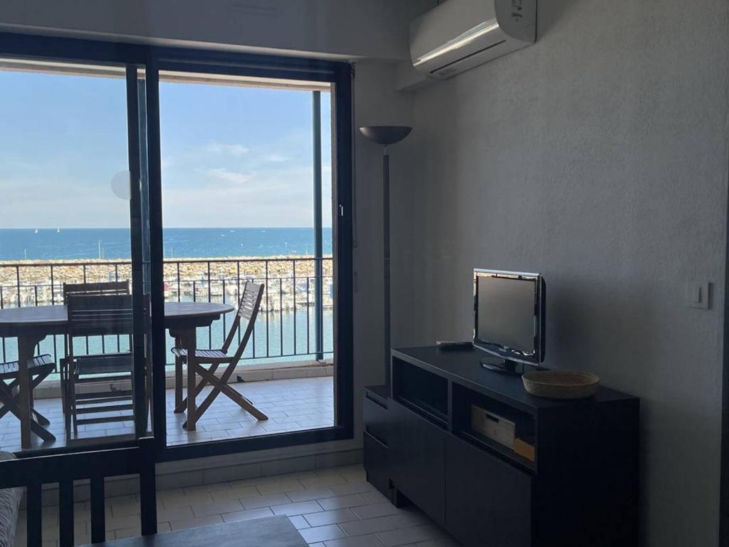 Cette chambre dispose d'un balcon avec une télévision et une table. dans l'établissement Appartement 2 pièces cabine - 5 pers, clim, parking privé, à 50m de la plage - FR-1-388-34, à Argelès-sur-Mer