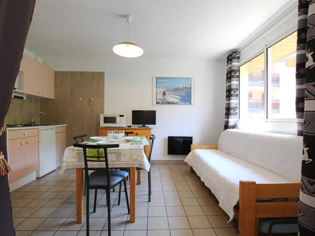 Cette chambre comprend un lit, une table et une cuisine. dans l'établissement Studio cosy avec balcon, proche des pistes et du centre de Briançon, pour 2-4 personnes - FR-1-330C-41, à Briançon