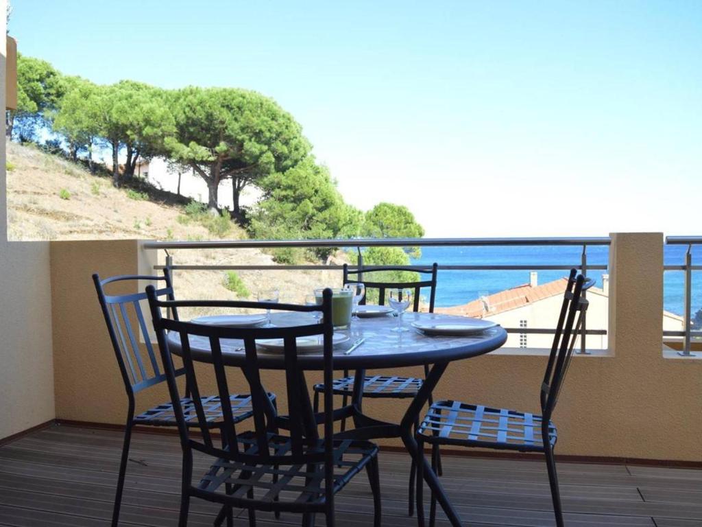 d'une table et de chaises sur un balcon avec vue sur l'océan. dans l'établissement Appartement Banyuls-sur-Mer, 3 pièces, 4 personnes - FR-1-225C-531, à Banyuls-sur-Mer