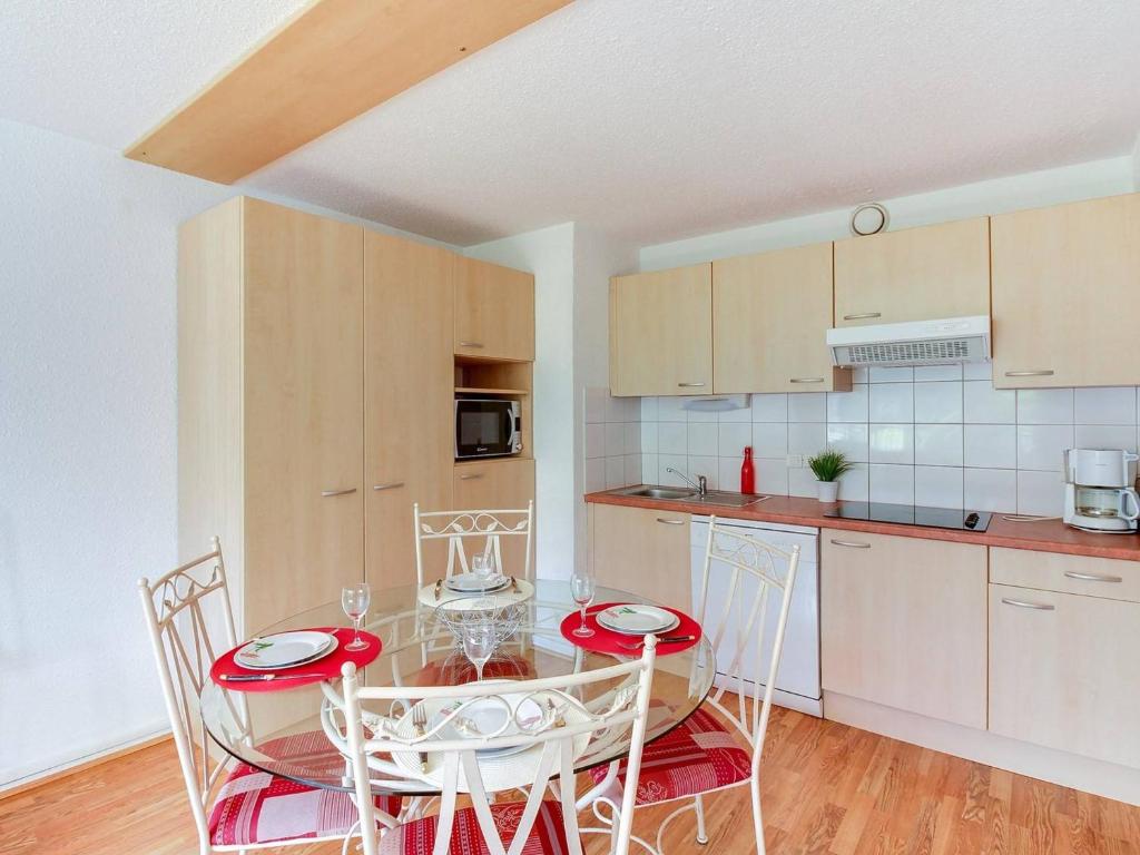 une cuisine avec une table et des chaises dans une pièce dans l'établissement Appartement Agréable 6 Pers, 2 Chambres, Centre Station, 80m des Pistes, Équipé et Confortable - FR-1-404-47, à La Mongie