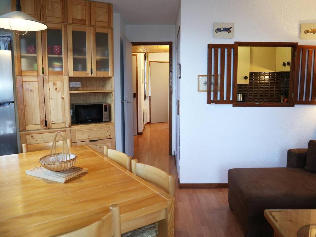 Il comprend un salon avec une table en bois et une cuisine. dans l'établissement Appartement confort 2P, 6 pers, cœur de station, accès direct pistes, cheminée, WiFi, TV, balcon ouest - FR-1-322-297, aux Orres