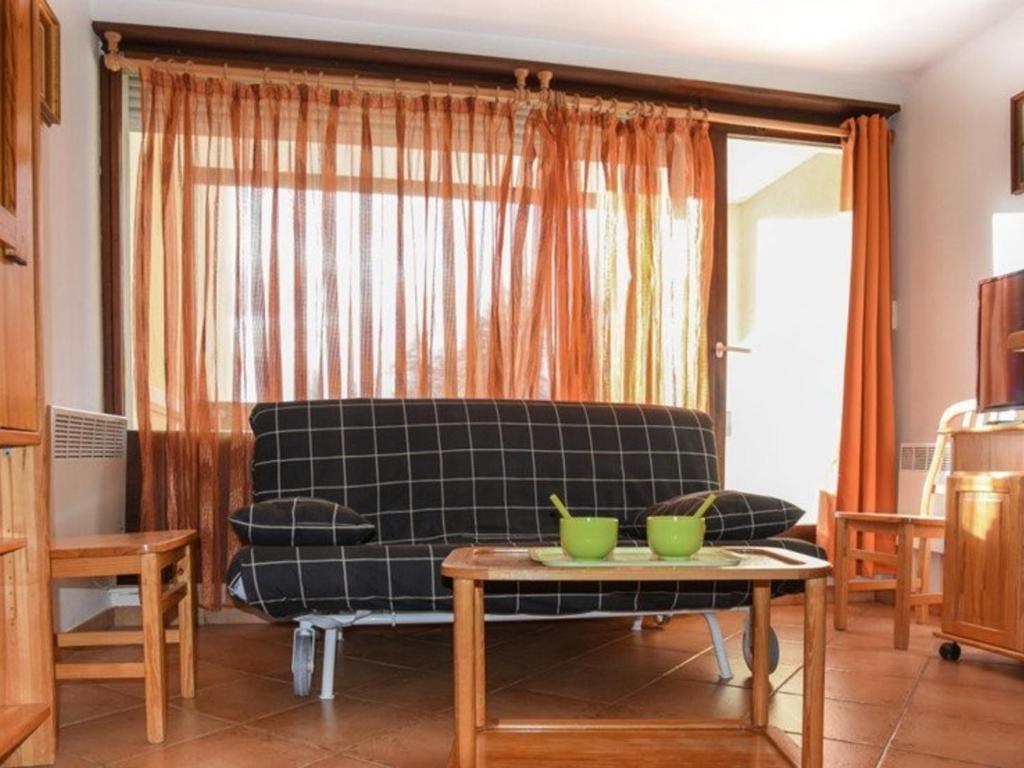 een woonkamer met een zwarte bank en een tafel bij Appartement Montgenèvre, 2 pièces, 5 personnes - FR-1-266-101 in Montgenèvre