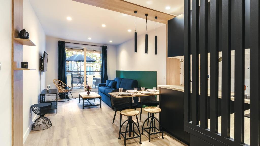 un salon avec un canapé bleu et une table dans l'établissement Beautiful Appt -1BR-4P- Porte d'Auteuil-Boulogne, à Boulogne-Billancourt