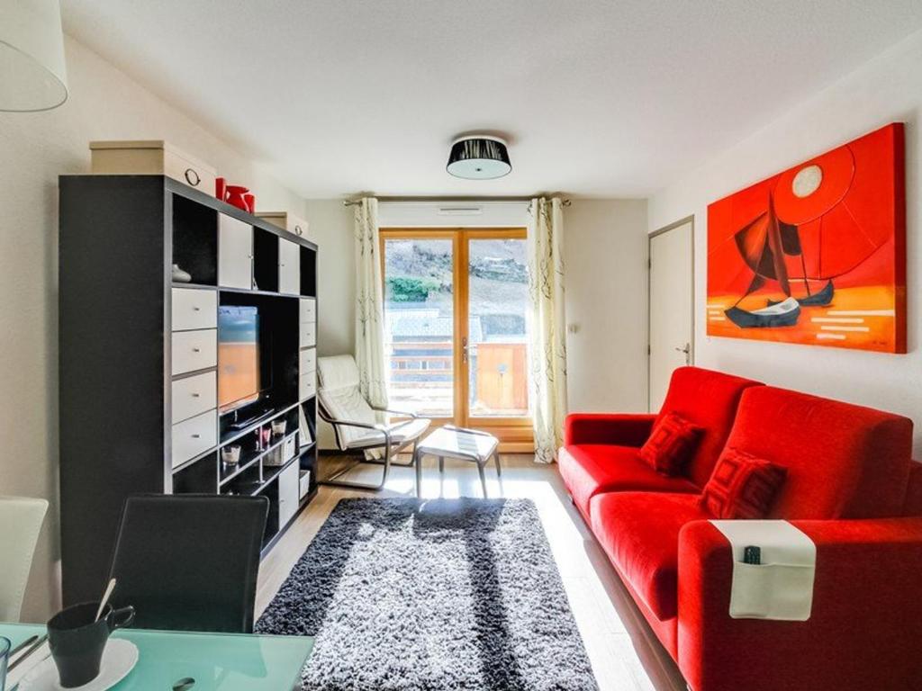 un salon avec un canapé rouge et une télévision dans l'établissement Appartement cosy 6 pers avec wifi, parking et balcon à Barèges - FR-1-403-76, à Barèges