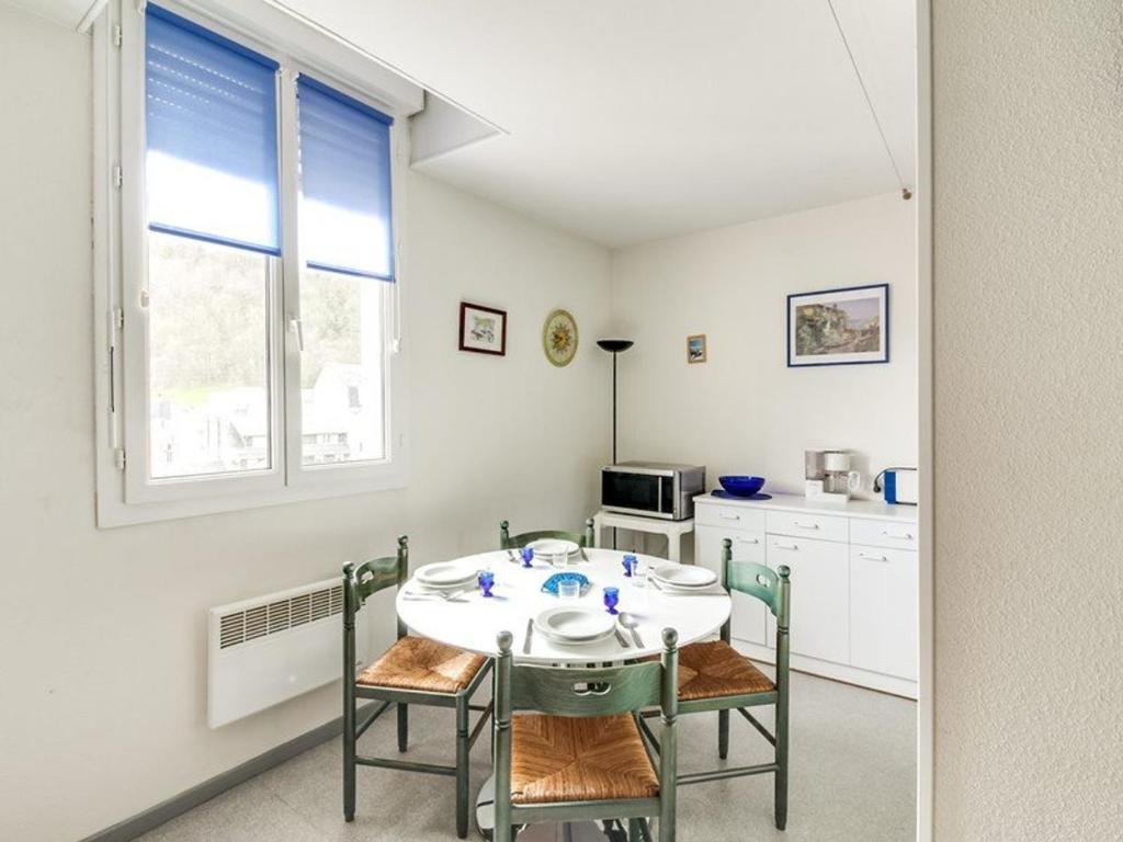 une cuisine avec une table et des chaises dans une pièce dans l'établissement Appartement cosy pour 4 personnes avec ascenseur, à 350m des pistes au centre de Cauterets - FR-1-401-25, à Cauterets
