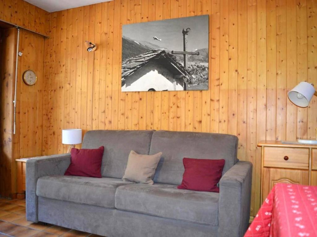 een woonkamer met een grijze bank met rode kussens bij Appartement Le Grand-Bornand, 1 pièce, 4 personnes - FR-1-241-185 in Le Grand-Bornand