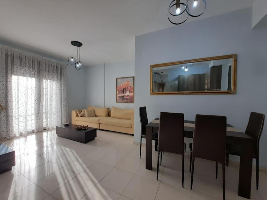 a living room with a table and chairs and a couch at Two bedroom modern apartment in Komotini