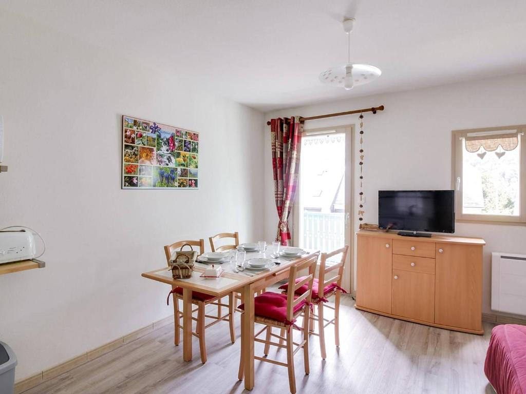una sala da pranzo con tavolo, sedie e televisione di Chalet Duplex 4 Pers. avec Parking, Proche Télécabine et Commerces, Ski à 1700m - FR-1-401-39 a Cauterets