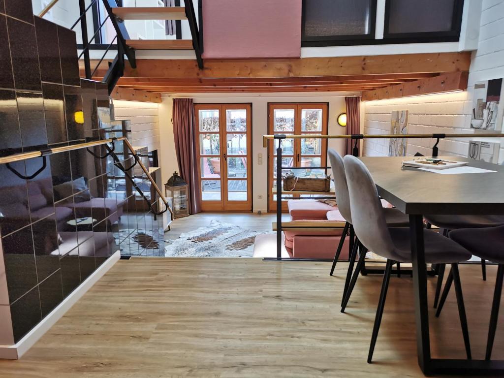 a room with a table and chairs and a staircase at Das goldene Haus in Sonthofen