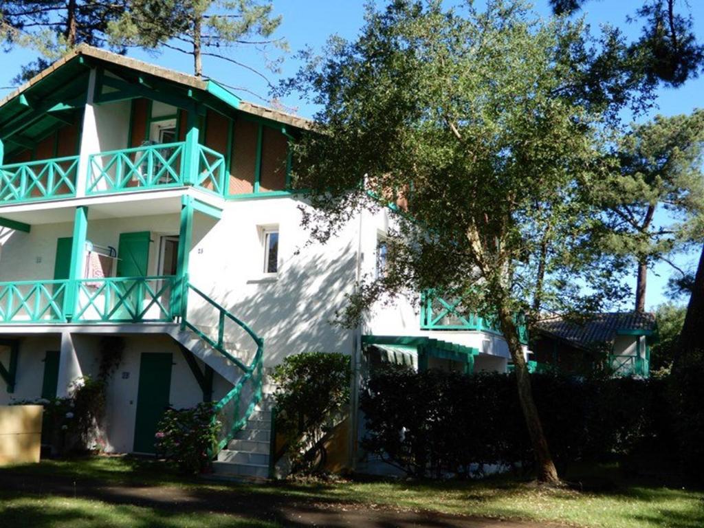 スーストンにあるAppartement Soustons, 3 pièces, 6 personnes - FR-1-379-78の緑のバルコニー付きの大きな白い家