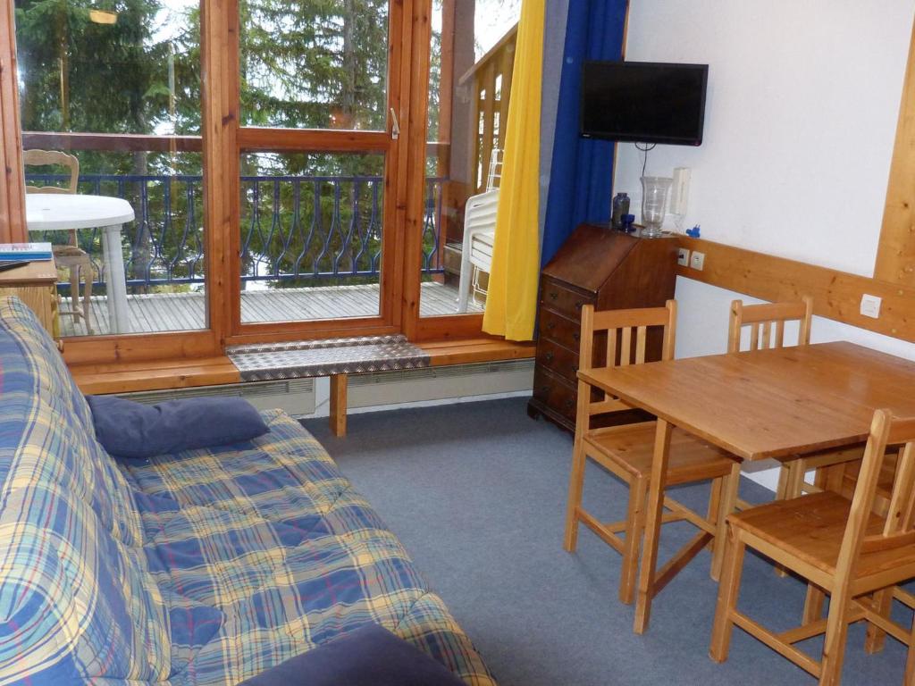 un salon avec un canapé, une table et une télévision dans l'établissement Appartement Duplex 2P 6 Pers. Skis aux Pieds, Village de Charmettoger, Arc 1800 - FR-1-411-219, à Arc 1800