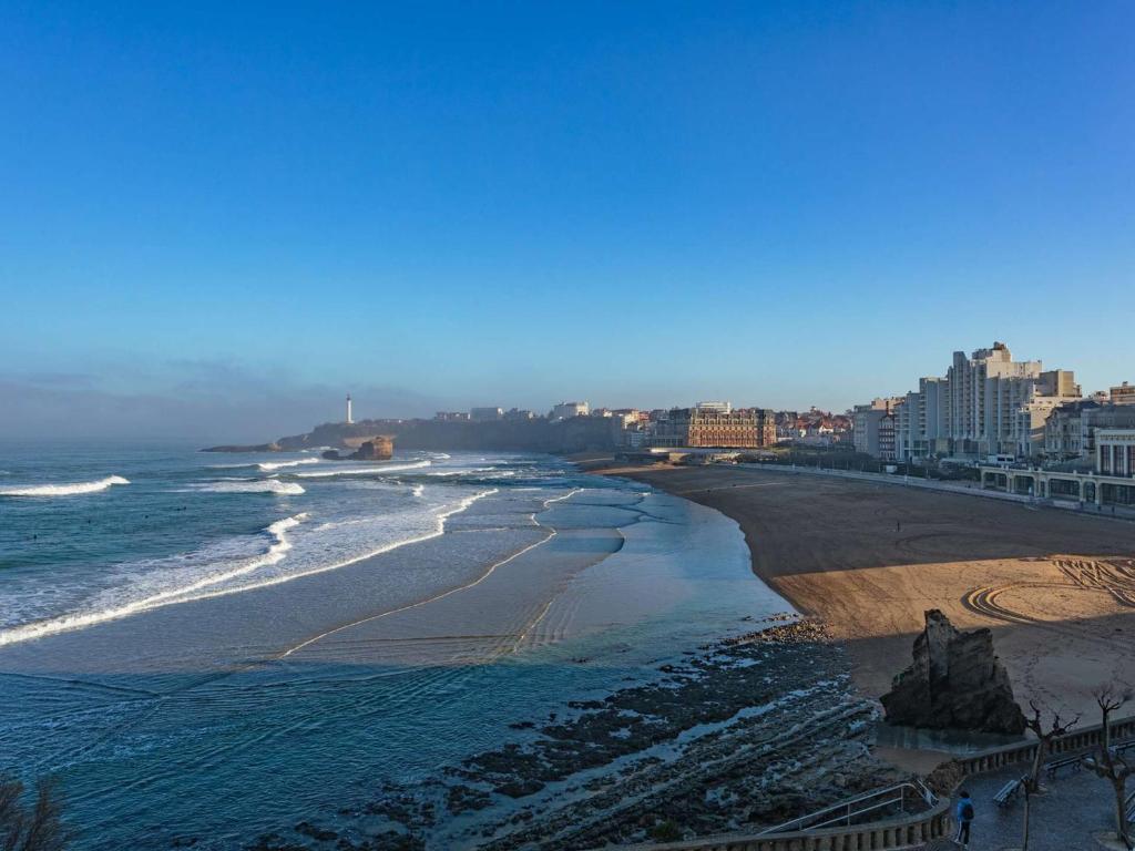 une vue d'une plage avec des bâtiments et l'océan dans l'établissement Studio cosy à Biarritz avec vue sur l'océan, 2e étage, ascenseur - FR-1-3-483, à Biarritz