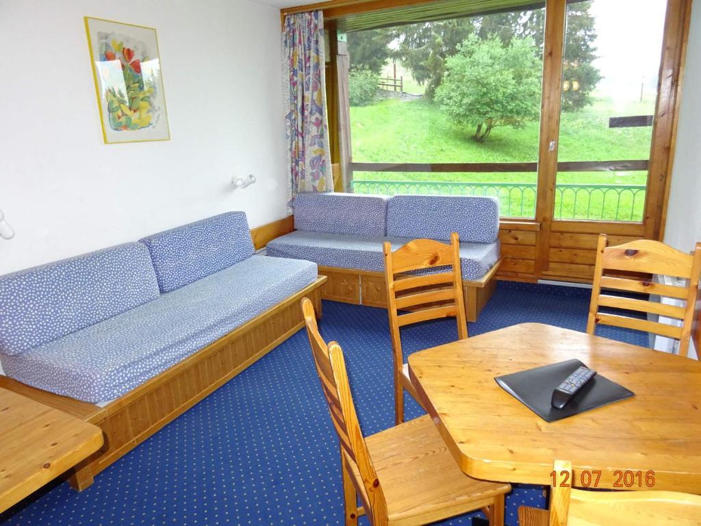 une chambre avec un canapé, des tables et une fenêtre dans l'établissement Studio skis aux pieds, proche commerces, animaux admis à Arc 1800 - FR-1-411-128, à Arc 1800