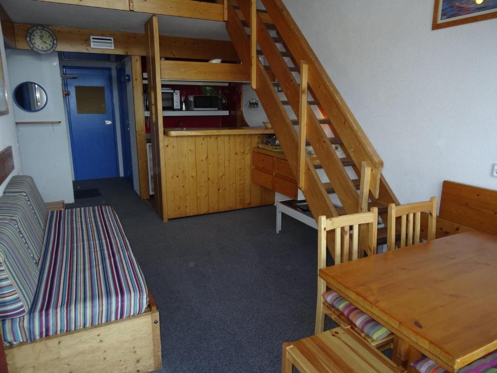 Cette chambre dispose d'un escalier, d'une table et d'une cuisine. dans l'établissement Appartement Duplex 52m², 7 pers, proche pistes/commerces, animaux admis, parking, Wi-Fi - FR-1-411-195, à Arc 1800