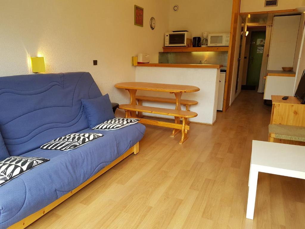 a living room with a blue couch and a table at Studio Les Arcs 2000, 1 pièce, 5 personnes - FR-1-411-350 in Arc 2000