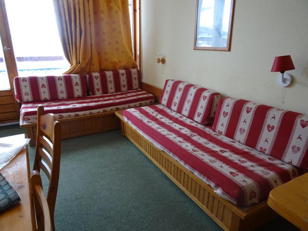 Cette chambre comprend 2 lits avec des sièges rouges et blancs. dans l'établissement Studio 5 personnes aux Arcs 1800, skis aux pieds, proche commerces, balcon, animaux acceptés. - FR-1-411-374, à Arc 1800