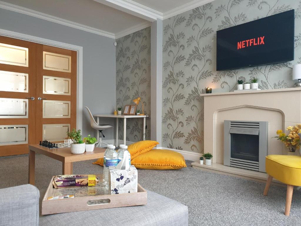 a living room with a fireplace and a tv at Spacious City Home with Free Parking, Fast Wi-Fi & Netflix in Coventry