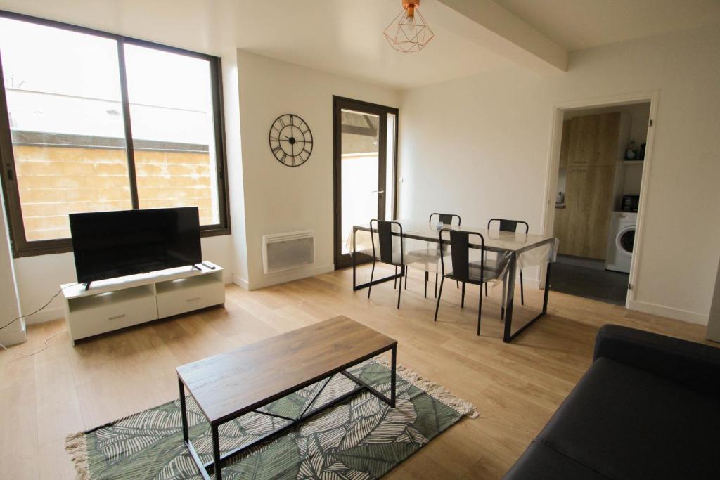un salon avec une table et une salle à manger dans l'établissement Le patio de Théo - proche gare - centre-ville, à Angoulême