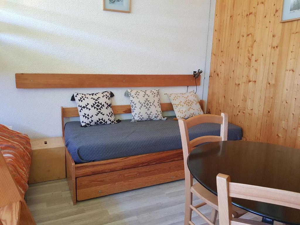 une petite chambre avec un lit et une table dans l'établissement Studio cosy pour 2 à Arc 1600, ski aux pieds, proche commerces et remontées mécaniques - FR-1-411-446, à Arc 1600