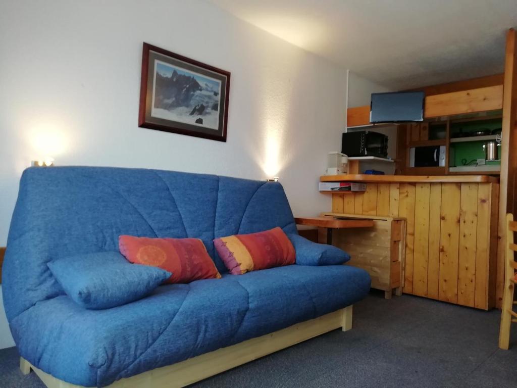 - un canapé bleu avec deux oreillers dans le salon dans l'établissement Studio skis aux pieds, 5 personnes, balcon, proche commerces, Arc 1800 - FR-1-411-448, à Bourg-Saint-Maurice