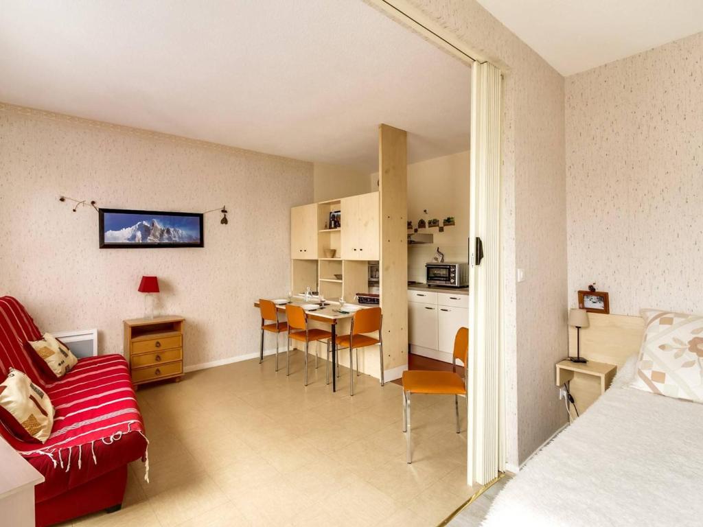 un salon avec un canapé rouge et une table dans l'établissement Studio en centre-ville avec 2 coins nuit, cuisine équipée et proche télécabine - 5 pers. - FR-1-401-116, à Cauterets