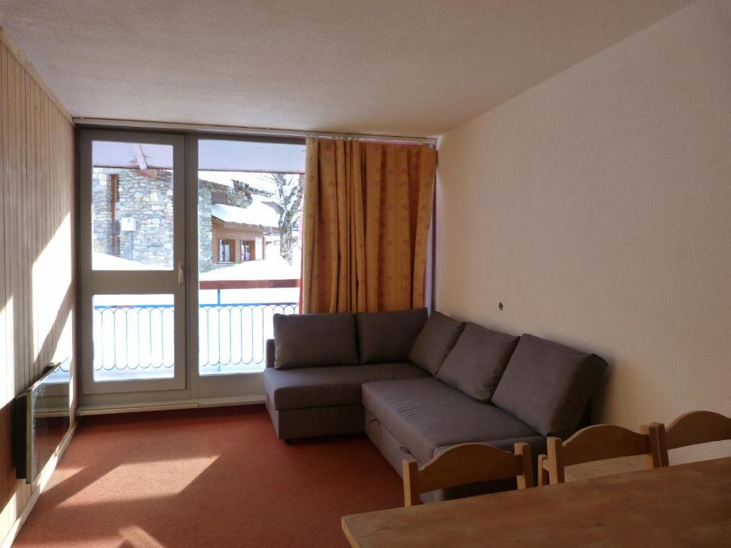 un salon avec un canapé et une grande fenêtre dans l'établissement Appartement 2 pièces pour 6 personnes, proche pistes et commerces, Arc 1800, Village des Villards - FR-1-411-507, à Arc 1800